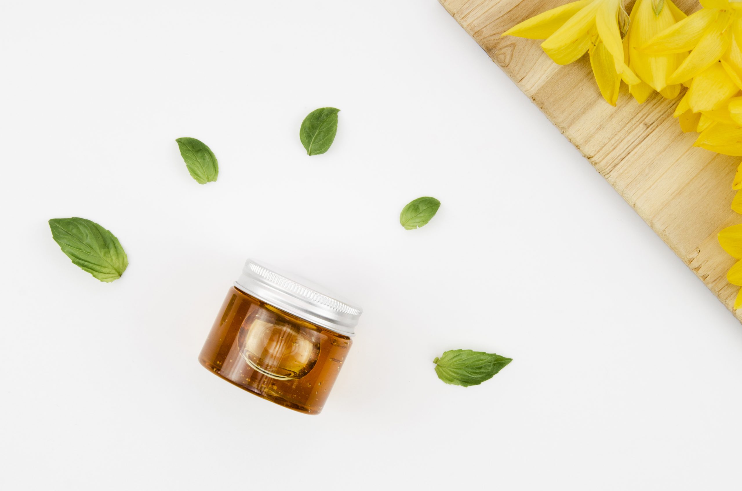 top-view-close-up-shot-jar-honey-with-flowers-leaves