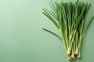 bunch-fresh-lemongrass-displayed-from-up-against-crisp-green-background A bunch of fresh lemongrass displayed from above and up against a crisp green background and space for textual use, Generative AI.