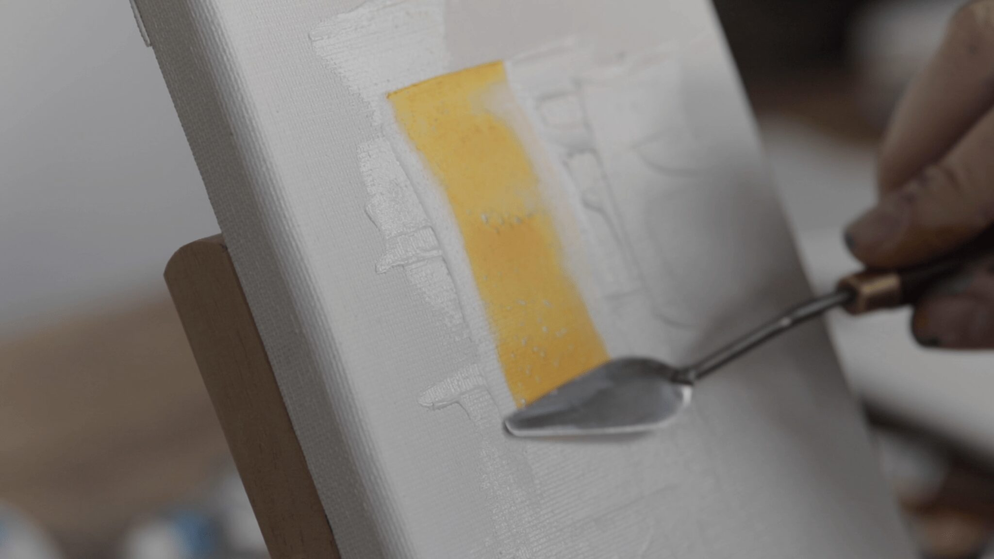 Detalj teksture profesionalnog slikarskog platna Daler Rowney Artists' tijekom nanošenja akrilne boje špahtlom.
