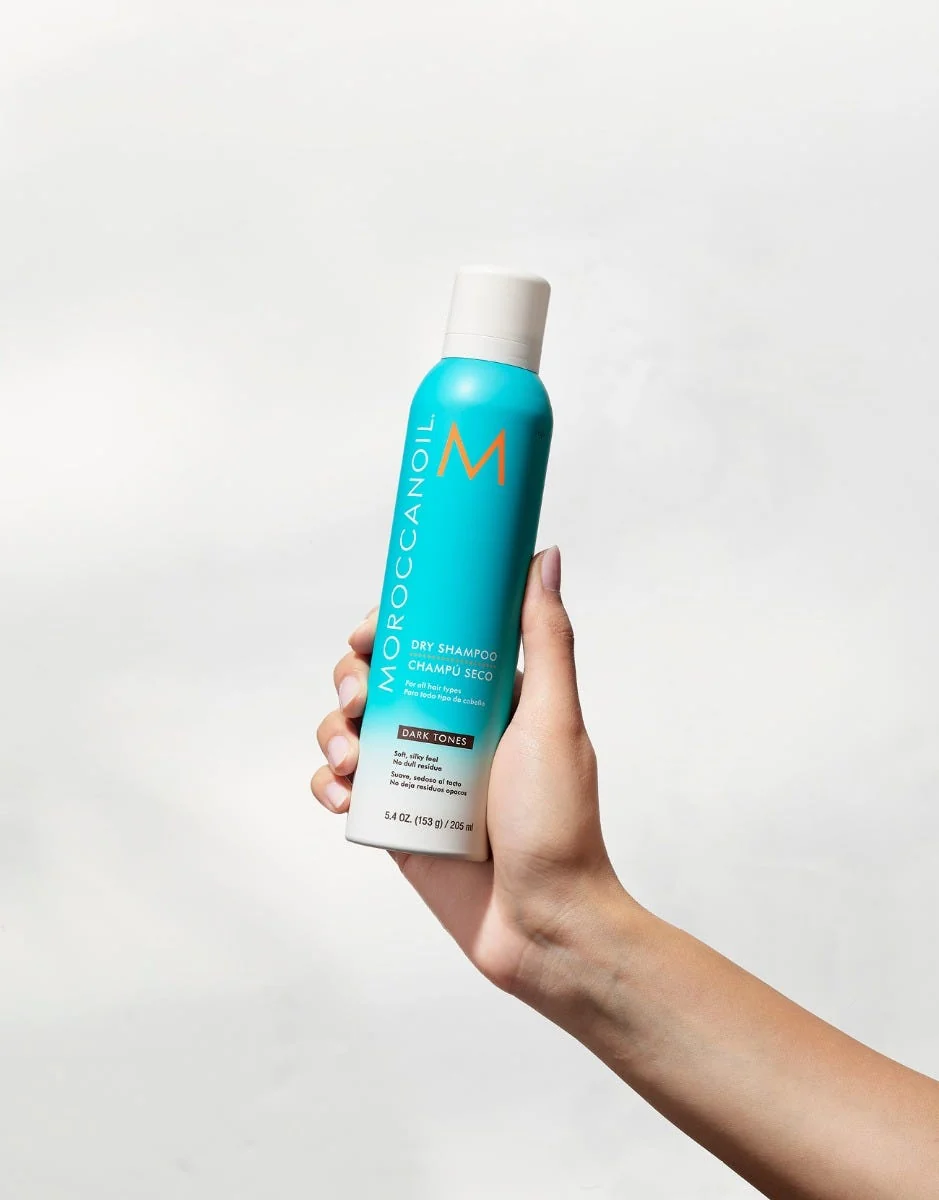 Moroccanoil Dry Shampoo Dark Tones bočica u ruci na svijetloj podlozi